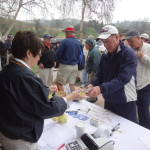 Sallie Vravis ('63) checking in golfers.