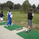 Bob Abbott and Terry Morales warm up before hitting the green